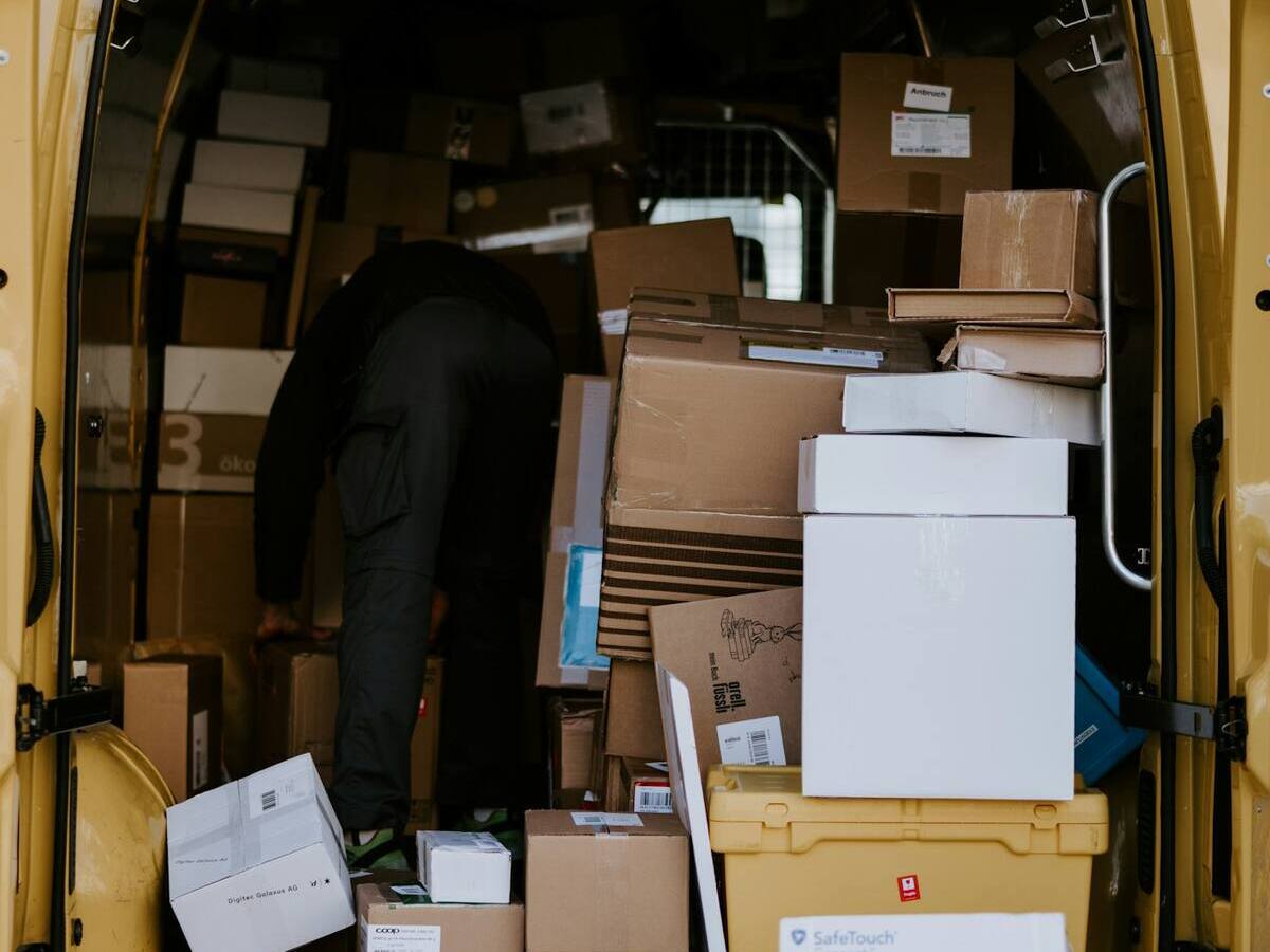 Courier loading boxes into a delivery van